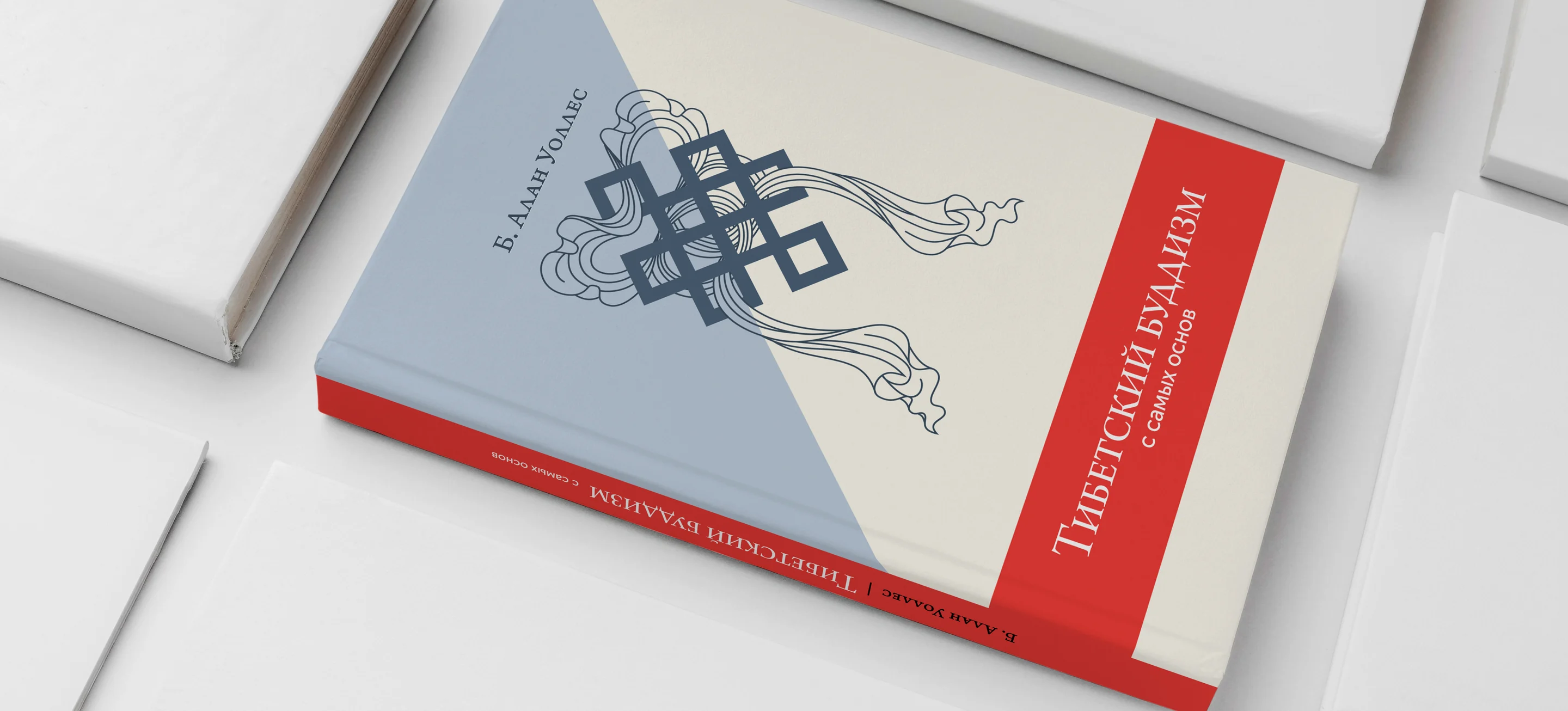 A hardback book lying on a white surface: a pale blue and cream cover with a dark blue endless-knot ornament trailing ribbons, and a red spine band reading Тибетский буддизм с самых основ.