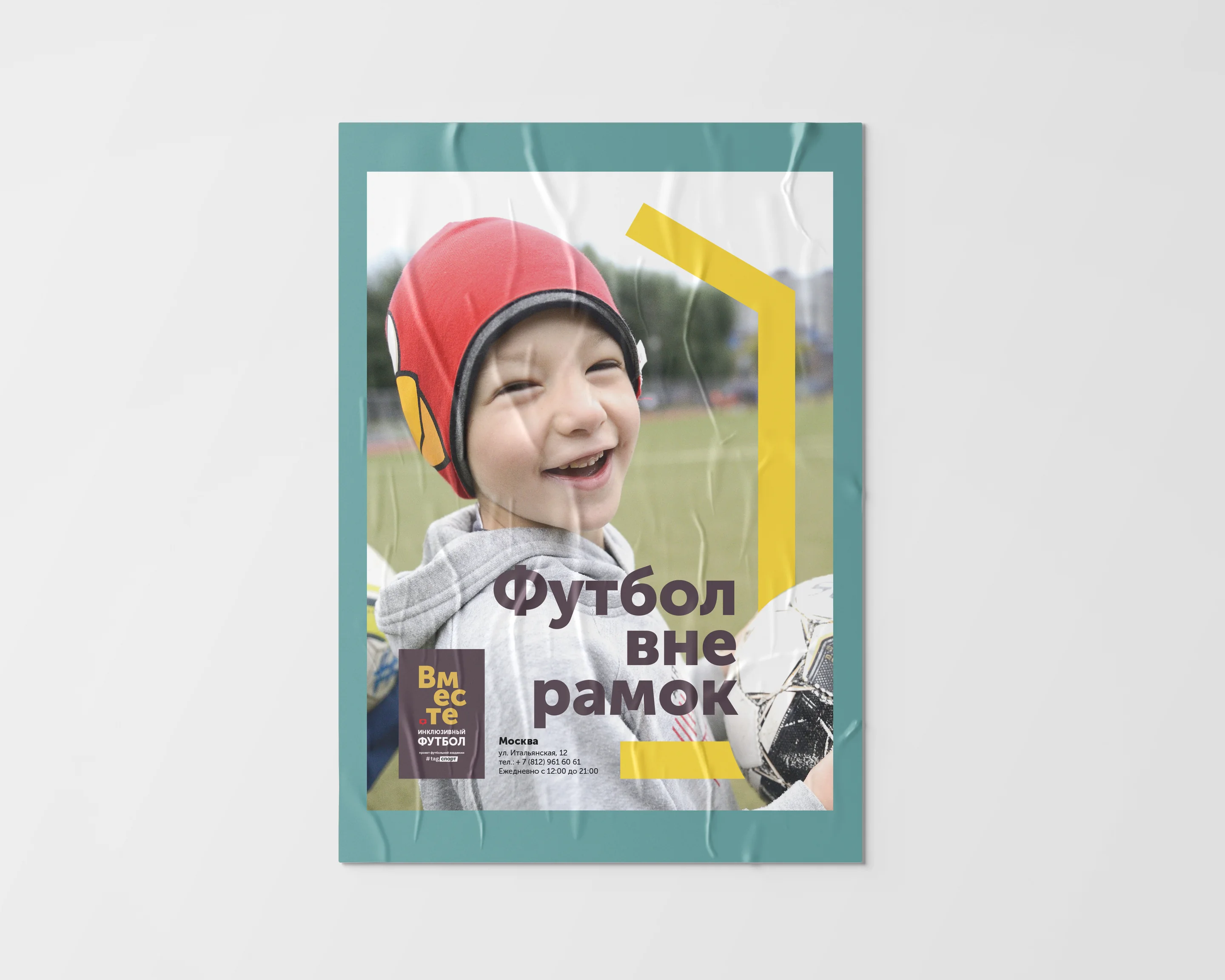 The Vmeste street poster pasted on a wall: a laughing boy in a red protective helmet on a football pitch, with the words Футбол вне рамок across it.